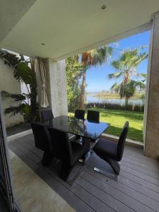 een eettafel met stoelen en uitzicht op de oceaan bij Apparemment luxueux Ritz Carlton in Sania Torres