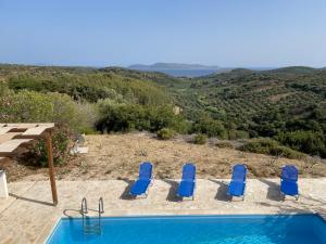 a swimming pool with blue chairs and a view at Villa Valleyview Methoni in Methoni