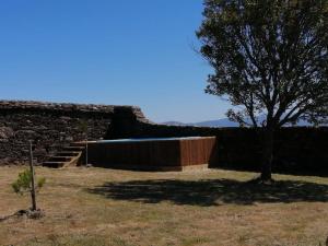 eine Wand mit Treppen und einem Baum auf einem Feld in der Unterkunft Quartéis de Santa Justa in Cerquido