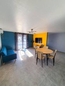 sala de estar con mesa y sofá azul en Villa Mon Caprice en Roquemaure