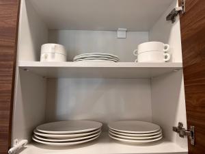 a cupboard with plates and mugs on it at Crystal Resort in Bakuriani