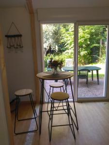 a table and two stools in a room with a patio at Pivert in Pléneuf-Val-André