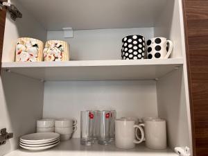 a cupboard filled with cups and plates and mugs at Crystal Resort in Bakuriani