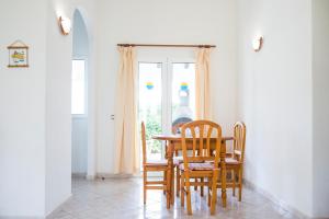 comedor con mesa, sillas y ventana en Apartchalet villas Elvira. Villa F, en Son Carrio