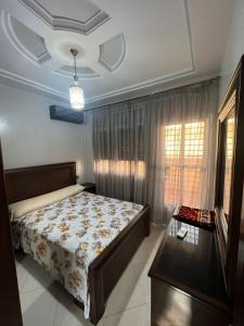 a bedroom with a bed and a large window at Appartement boulaàyoun de luxe à louer nador 3 in Nador