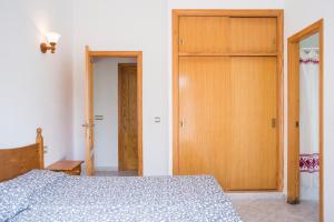 1 dormitorio con 1 cama y puerta de madera en Apartchalet villas Elvira. Villa F, en Son Carrio