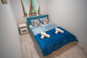 a bedroom with a blue bed with two teddy bears on it at Ostoja Leśna in Karpacz