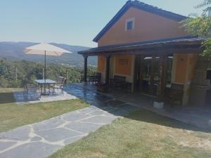 a house with a table and an umbrella at Casa Antonio in Susañe del Sil