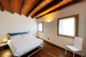 1 dormitorio con 1 cama, 1 silla y 1 ventana en ValdoCaban: Oasis among the Vines, en Santo Stefano