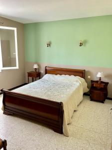 um quarto com uma cama grande e duas mesas de cabeceira em Les oliviers du pradon em Lagarde-Paréol