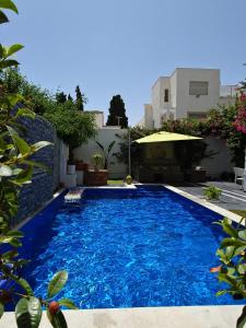 una grande piscina blu di fronte a un edificio di Villa de Charme Adultes Only a Nabeul