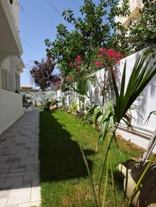 納布勒的住宿－Villa de Charme Adultes Only，白色围栏旁的粉红色花卉花园