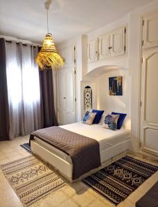 a bedroom with a bed and a chandelier at Villa de Charme Adultes Only in Nabeul
