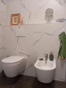 a white bathroom with a toilet and a sink at Private apartment in Usha studio in Ljubljana