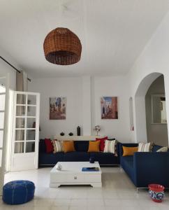 a living room with a blue couch and a table at Villa de Charme Adultes Only in Nabeul