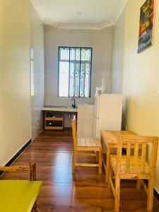 a kitchen with a table and chairs and a refrigerator at Mbuyu Uvi Apartment in Paje