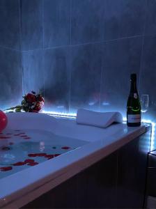 a bottle of wine sitting next to a bath tub at Casa degli Orti, Dolomia best home in Trento