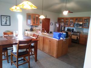 a kitchen with wooden cabinets and a table with chairs at Ocean View Paradise! in Hawaiian Ocean View