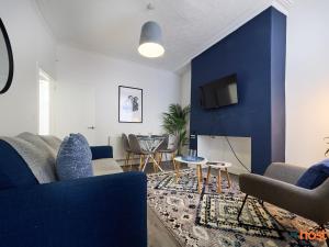 a living room with a blue accent wall at Host Liverpool - Smithdown Hub, Shops & Eats, by centre in Liverpool