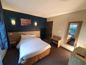 - une chambre avec un grand lit blanc et un miroir dans l'établissement Hotel Salea, à Pornic