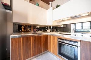 a kitchen with white cabinets and a dishwasher at Suite 46 attico con Vista cielo Milano in Milan
