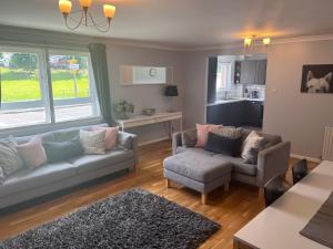 a living room with two couches and a kitchen at Flat Two, 212 Eaglesham Road, East Kilbride, Glasgow in Glasgow