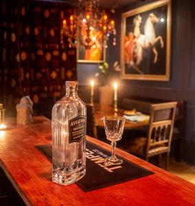 une bouteille de vodka assise sur une table avec un verre dans l'établissement Red Lion, Coorie Inn, à Earlston