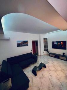 a living room with a couch and a flat screen tv at casa vacanze VIVA House Sicily in Alcamo