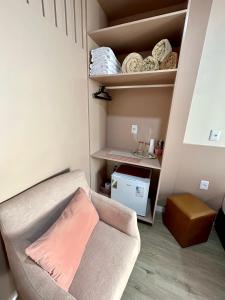 a living room with a couch and a shelf at Pousada Rota do Sol Quarto Filial Rose 11 in Penha