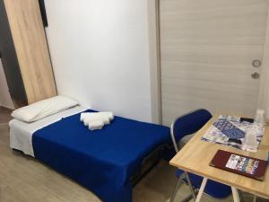 a small bedroom with a blue bed and a table at Casa di Angela in Sciacca