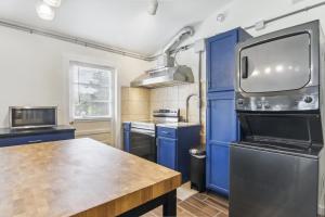a kitchen with blue cabinets and a wooden table at Modern Cambridge Cottage Walk to Town, Waterfront in Cambridge