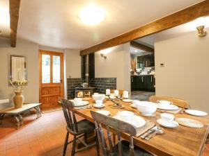 uma sala de jantar com uma mesa de madeira e cadeiras em Wheatlow Brooks Barn em Stafford