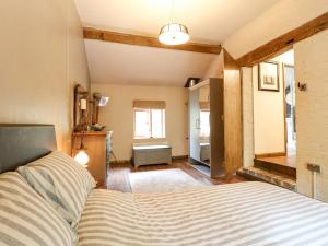 a bedroom with a bed and a room with a window at Wheatlow Brooks Barn in Stafford