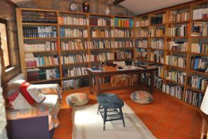 a library filled with book shelves filled with books at Cozy Family Home in Amazing Mountain with piano in Candemil