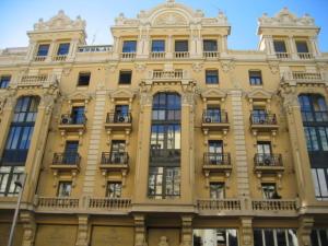un gran edificio amarillo con ventanas y balcones en Hostal Splendid - Gran Vía, en Madrid