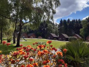 a park with a bench and flowers in the grass at Alpine Park Cottages in Aylesbeare