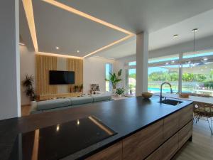 una cocina con una gran isla en la sala de estar en Casa con piscina en Liméns, en Hío