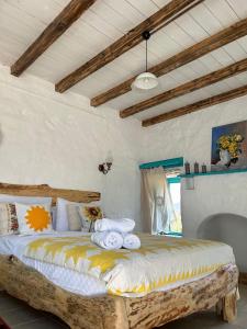 - une chambre avec un lit et des serviettes dans l'établissement Güneş Butik Otel Datça, à Cumalı