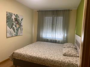 a small bedroom with a bed and a window at Casa Cristina - Rioja II in Cenicero