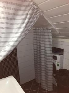 ein Badezimmer mit einer Waschmaschine und einem Duschvorhang in der Unterkunft Skålafjæro 25 in Rosendal