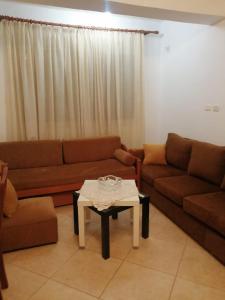 uma sala de estar com um sofá e uma mesa em Maria Apartment em Gjirokastër