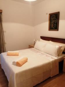 a bedroom with a bed with two towels on it at Maria Apartment in Gjirokastër