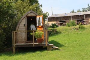 a out house with a potted plant in a yard at Knapp Farm Glamping Puki Pod in Corscombe