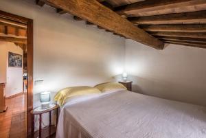 - une chambre avec un lit dans une pièce dotée de plafonds en bois dans l'établissement Nonna Gio', à Radicondoli