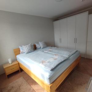 Appartment Relaxtage في زنغست: غرفة نوم بسرير كبير مع دواليب بيضاء