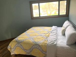 1 dormitorio con 1 cama con edredón y ventana en Unique Octagon House near Cedar Point, en Huron