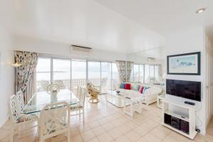 Una sala de estar con un sofá, una mesa y un televisor. en Oceana Suites Vanguardia, en Punta del Este