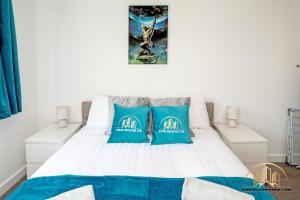 a bedroom with a bed with two blue pillows at Atlas Apartment - The Pillar of Town in Southampton
