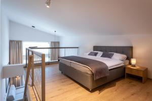 a bedroom with a large bed and a balcony at TALBERG SK - Garage parking - Quiet place - Brand new apartments - Tále in Tale