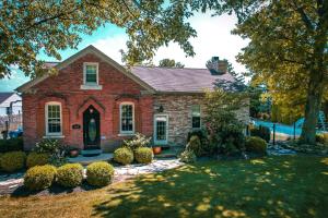 una casa de ladrillo rojo con un patio paisajista en Charming School House with Large Pool, en Huron